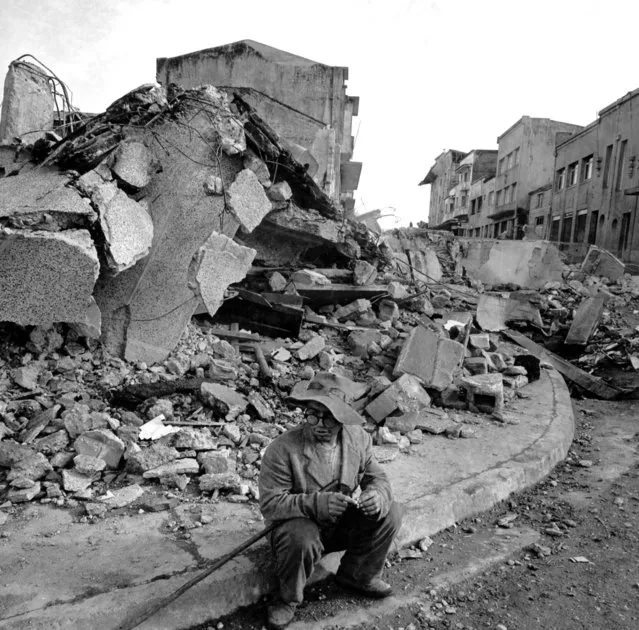 A lone resident of the southern Chile town of Castro sits on a curb in the downtown area May 30, 1960 after the section was hit by devistating earthquakes.  The rubble in the backround was once  business establishments.  (Photo by William J. Smith/AP Photo)