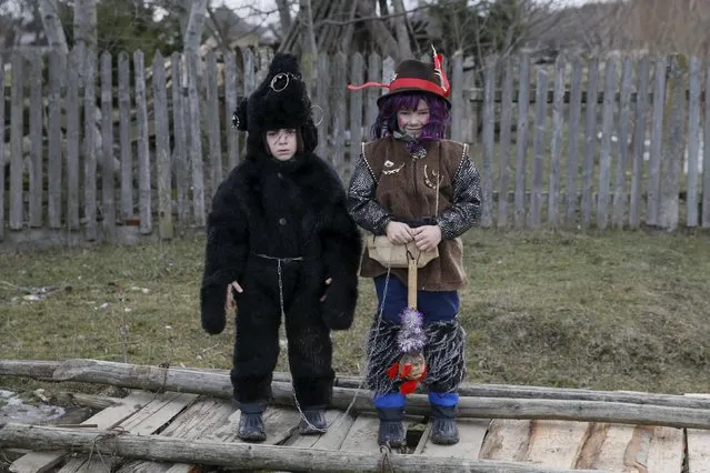 Boys, dressed in costumes of a bear and a gypsy, pose for a picture while visiting local houses during the celebrations for Malanka holiday in the village of Krasnoilsk in Chernivtsi region, Ukraine, January 13, 2016. (Photo by Valentyn Ogirenko/Reuters)