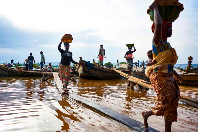 Malian women unload river sand from boats moored in the port of Bamako on September 30, 2018. (Photo by Michele Cattani/AFP Photo)