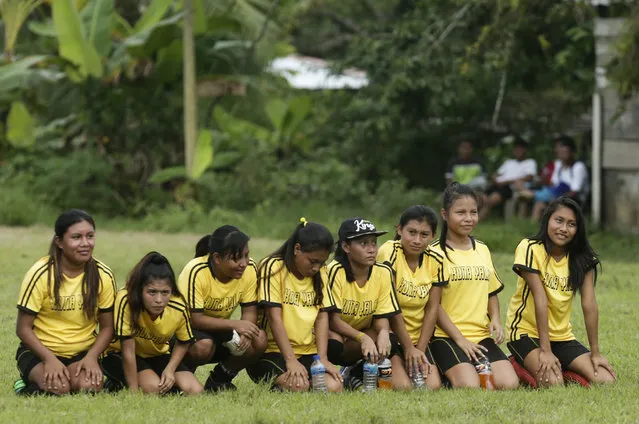 In this November 25, 2018 photo, a group of Guna women sit on the field during a penalty shootout in the women's soccer competition of the second edition of the Panamanian indigenous games in Piriati, Panama. The Guna women won the match and advanced to the semifinal and won the championship. (Photo by Arnulfo Franco/AP Photo)