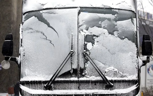 A bus window is covered by snow and ice, Sunday, February 14, 2016, in Evanston, Ill. Snow has now overspread nearly all of the Chicago Metro area early Sunday afternoon and is expected to continue into the night before ending. (Photo by Nam Y. Huh/AP Photo)