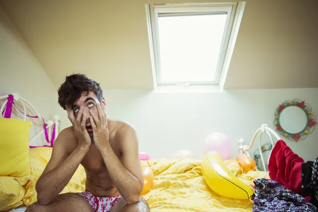 Hungover man rubbing face on bed the morning after a party. (Photo by Paul Bradbury/Getty Images/Caiaimage)