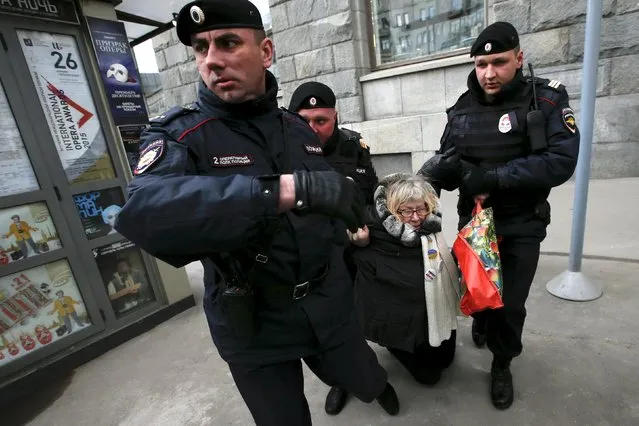 Russian police detain a protester against Russian President Vladimir Putin after she took part in a lone picket in central Moscow April 19, 2015. (Photo by Maxim Zmeyev/Reuters)