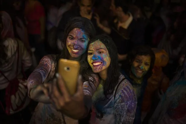 Revelers take a selfie during a Holi Festival in Madrid, Spain, Sunday, April 26, 2015. The festival is based on the Hindu spring festival Holi, also known as the festival of colours where participants colour each other with dry powder and coloured water. (Photo by Andres Kudacki/AP Photo)