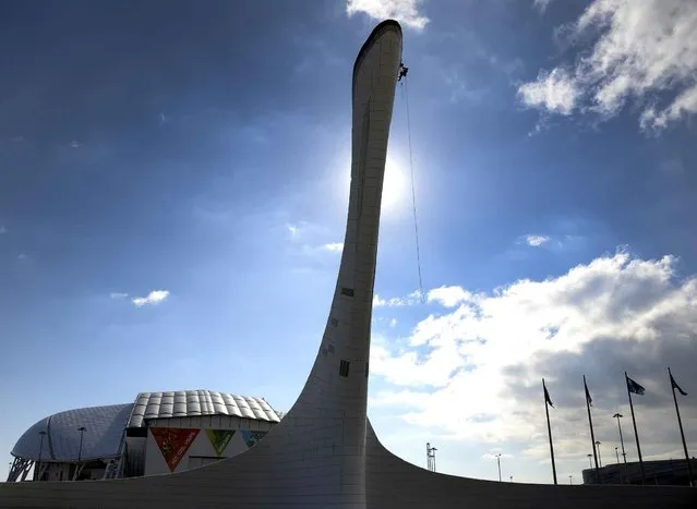 Workers check the Olympic cauldron at the Olympic Park's medals plaza in the seaside cluster prior to the start of the 2014 Sochi Winter Olympics on February 2, 2014 in Sochi. (Photo by Alexander Nemenov/AFP Photo)