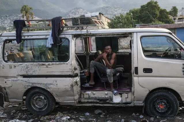 A man rests in an abandoned truck during the general strike in Port-au-Prince, Haiti, Monday, October 18, 2021. (Photo by Matias Delacroix/AP Photo)
