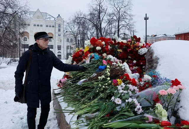 A man lays flowers at the Solovetsky Stone monument to the victims of political repressions to honour the memory of Russian opposition leader Alexei Navalny in Moscow, Russia on February 17, 2024. (Photo by Reuters/Stringer)