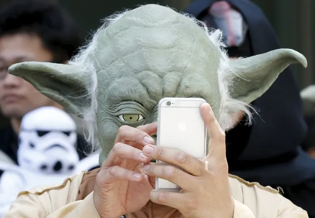 A cosplayer dressed up as Star Wars character Yoda looks at a mobile phone at a Star Wars Day fan event in Tokyo May 4, 2015. (Photo by Toru Hanai/Reuters)