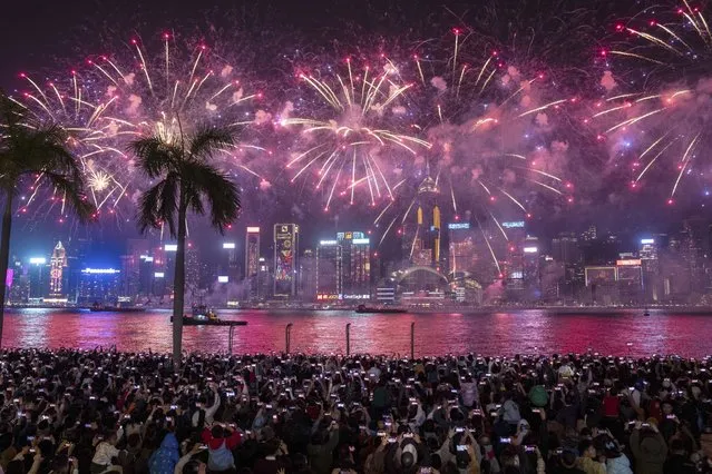Crowd watch fireworks lighting up over Victoria Harbour on the second day of the Lunar New Year of the Dragon, in Hong Kong, Sunday, February 11, 2024. (Photo by Louise Delmotte/AP Photo)
