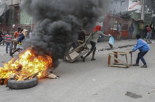 Protesters set up a barricade in the street during a demonstration demanding the resignation of Prime Minister Ariel Henry in Port-au-Prince, Haiti, Wednesday, February 7, 2024. (Photo by Odelyn Joseph/AP Photo)
