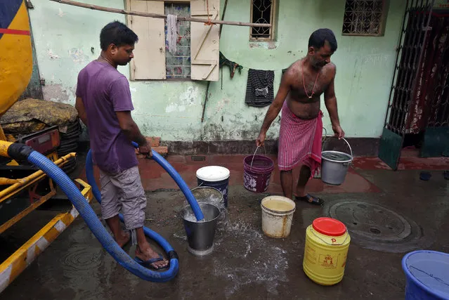 Residents fill containers with drinking water from a municipal water tanker at a slum in Kolkata, India, March 22, 2016. (Photo by Rupak De Chowdhuri/Reuters)