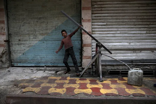 A boy fills a container with water in the town of Douma, eastern Ghouta in Damascus, Syria November 17, 2015. (Photo by Bassam Khabieh/Reuters)