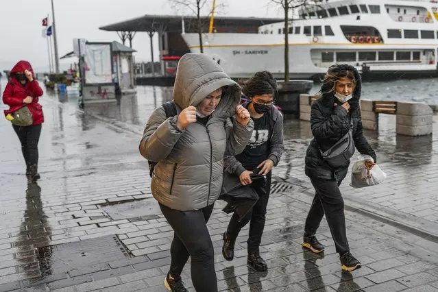 People run under a heavy rain during a stormy day in Istanbul, Turkey, Monday, November 29, 2021. A powerful storm pounded Istanbul and other parts of Turkey on Monday, killing at least four people and causing havoc in the city of 15 million people, reports said. (Photo by AP Photo/Stringer)