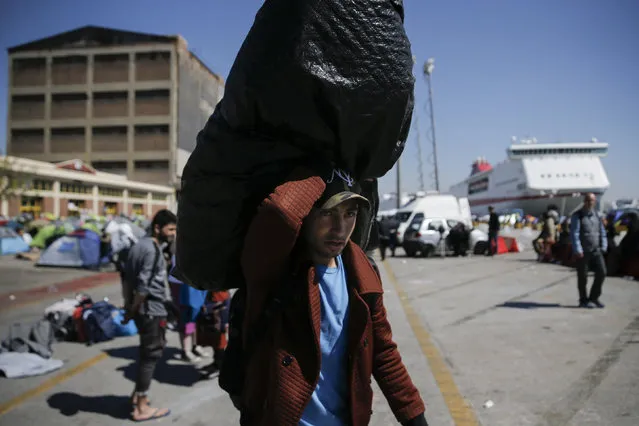 A refugee carries his belongings before boarding a bus heading to other parts of the country where refugees and migrants will be accommodated, at the port of Piraeus, near Athens, Greece March 31, 2016. (Photo by Alkis Konstantinidis/Reuters)