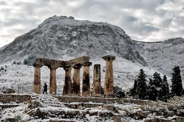 A person walks by the snow-covered temple of Apollon in Ancient Corinth on January 8, 2017. Greece experiences rare cold wave with low temperatures and snowfalls in many regions of the country. (Photo by Valerie Gache/AFP Photo)