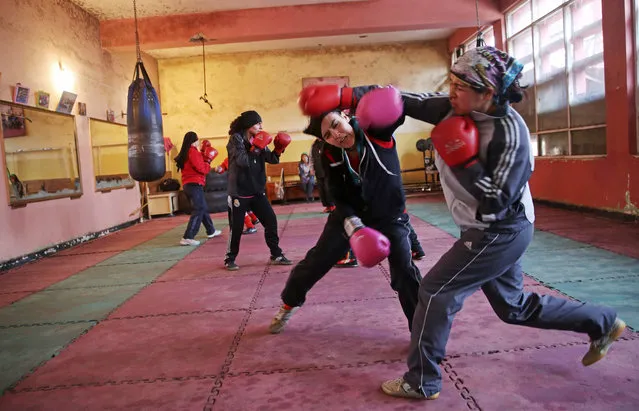 In this Wednesday, March, 5, 2014 photo, Afghan women boxers practice at the Kabul stadium boxing club. A few yellow lamps light up the cavernous, sparsely furnished room where Afghanistan's young female boxers train, hoping to become good enough to compete in the 2016 Olympics. (Photo by Massoud Hossaini/AP Photo)