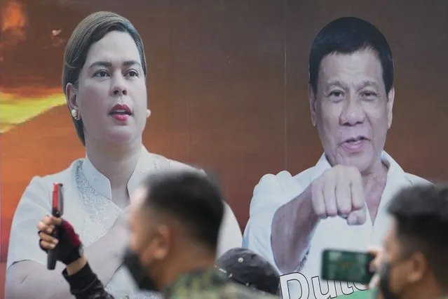 A vehicle bearing photos of Philippine President Rodrigo Duterte, right, and his daughter Davao City Mayor Sara Duterte passes by outside the Commission on Elections in Manila, Philippines, Monday, November 15, 2021. Duterte filed his candidacy Monday for a Senate seat in next year's elections, walking back on his announcement that he would retire from politics when his term ends and prompting human rights activists to press allegations that he would do anything to cling to power to evade accountability for his deadly anti-drugs crackdown. (Photo by Aaron Favila/AP Photo)