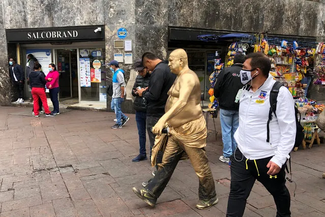 A man covered in gold paint walks in a pedestrian area in downtown Santiago, Chile, February 16, 2021. (Photo by Ivan Alvarado/Reuters)