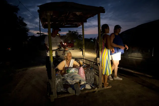 A relative carries 100-year-old Mariana Trivino in a rickshaw, after receiving food and water in Canoa, Ecuador, Thursday, April 21, 2016. President Rafael Correa said Ecuador's worst earthquake in decades caused billions of dollars of damage and he is raising sales taxes and putting a one-time levy on millionaires to help pay for reconstruction. (Photo by Rodrigo Abd/AP Photo)