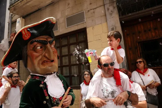 A boy uses his bubble pistol on a “Kiliki” during San Fermin festival's “Comparsa de gigantes y cabezudos” (Parade of the Giants and Big Heads) in Pamplona, Spain, July 8, 2019. (Photo by Susana Vera/Reuters)