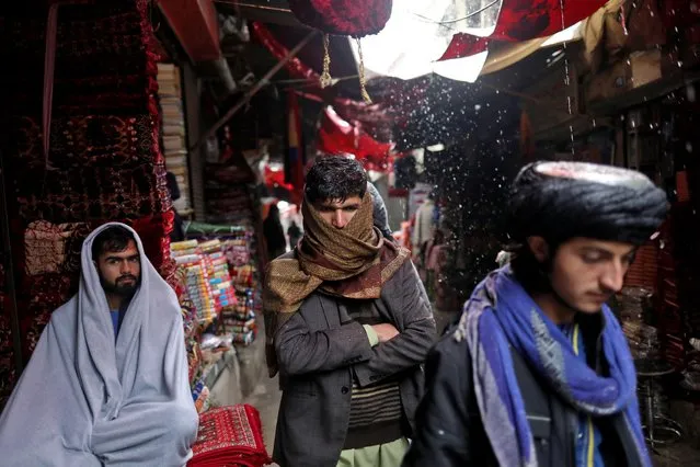Afghan men walk on a street during a snowfall in Kabul, Afghanistan, January 3, 2022. (Photo by Ali Khara/Reuters)