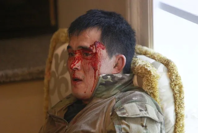 A member of Kyrgyz state security forces, who was injured during an operation to detain Almazbek Atambayev, lies on the floor in a house in the village of Koi Tash near Bishkek, Kyrgyzstan August 7, 2019. (Photo by Vladimir Pirogov/Reuters)