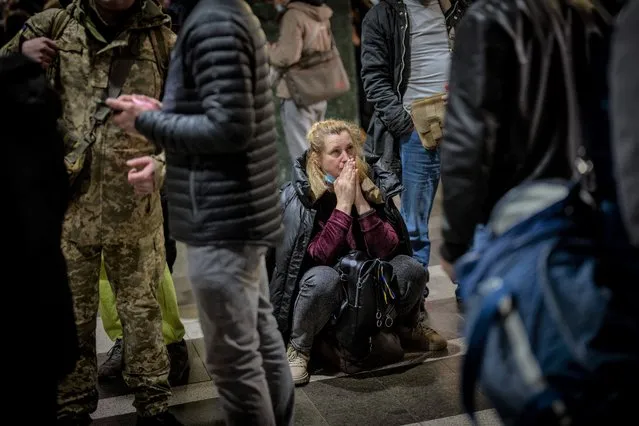 A woman reacts as she waits for a train trying to leave Kyiv, Ukraine, Thursday, February 24, 2022. Russian troops have launched their anticipated attack on Ukraine. Big explosions were heard before dawn in Kyiv, Kharkiv and Odesa as world leaders decried the start of an Russian invasion that could cause massive casualties and topple Ukraine's democratically elected government. (Photo by Emilio Morenatti/AP Photo)