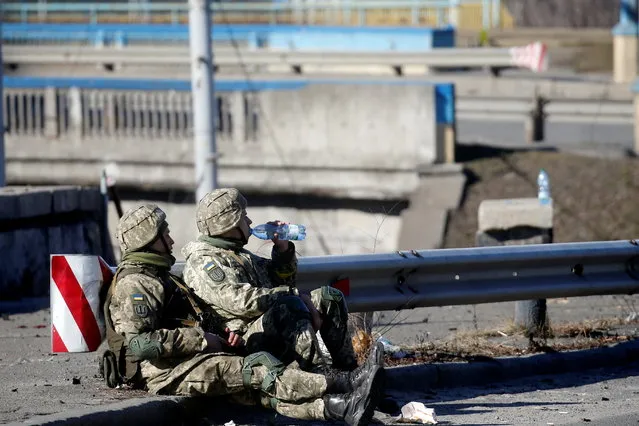 Ukrainian service members rest following a night fight, after Russia launched a massive military operation against Ukraine, in Kyiv, Ukraine on February 26, 2022. (Photo by Valentyn Ogirenko/Reuters)