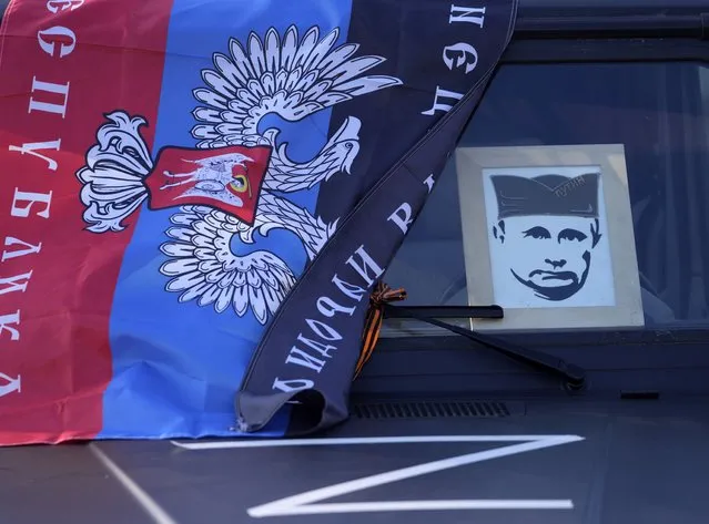 A car with flag of the breakaway Donetsk People's Republic and graphics depicting the Russian President Vladimir Putin wearing a traditional Serbian hat seen during a rally in support of Russia in Belgrade, Serbia, Sunday, March 13, 2022. Despite formally seeking EU membership, Serbia has refused to introduce international sanctions against its ally Russia. EU officials have repeatedly warned Serbia that it will have to align itself with the bloc's foreign policies if it wants to join. (Photo by Darko Vojinovic/AP Photo)