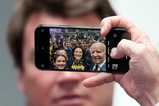 President Joe Biden holds a cellphone as he takes a picture with a members of the audience after making a speech about Northern Ireland's vast economic potential at the Ulster University's new campus in Belfast, Northern Ireland, Wednesday, April 12, 2023. President Biden is in Northern Ireland on Wednesday to participate in marking the 25th anniversary of the Good Friday Agreement, which brought peace to this part of the United Kingdom, as a new political crisis tests the strength of that peace. (Photo by Christophe Ena/AP Photo)