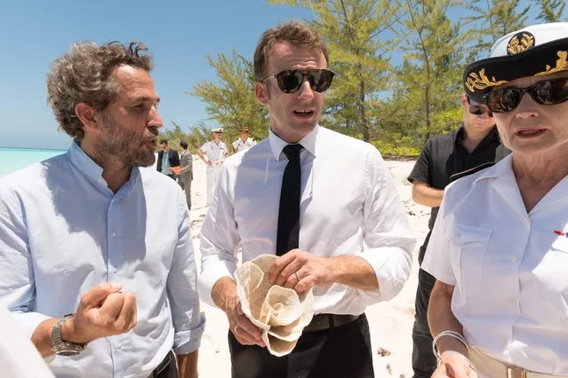 French President Emmanuel Macron holding a piece of 'lettuce coral' speaks with scientist Romain Trouble during a visit to the French Island of La Grande Glorieuse, part of Les Glorieuses islands in the Eparses archipelago, 250km northeast of the French Indian Ocean island of Mayotte, on October 23, 2019. Macron announced that the island, whose French sovereignty is contested by Madagascar, will be classified as a natural reserve. (Photo by Jacques Witt/AFP Photo/Pool)