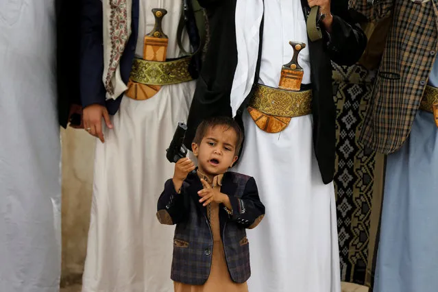 A boy holds his father's pistol as he attends with tribesmen loyal to the Houthi movement a gathering to show support to the movement in Sanaa, Yemen, May 26, 2016. (Photo by Khaled Abdullah/Reuters)