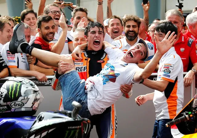 Spain's rider Marc Marquez, center, celebrates with his brother Spain's Moto2 rider Alex Marquez after winning the second place of MotoGP race at the Malaysia Motorcycle Grand Prix at Sepang International circuit in Sepang, Sunday, November 3, 2019. (Photo by Lai Seng Sin/Reuters)