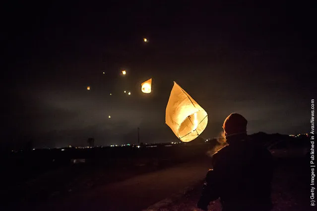 Families release a paper lantern into the sky in commemoration of the victims of last year's earthquake and tsunami, on March 11, 2012 in Natori, Japan