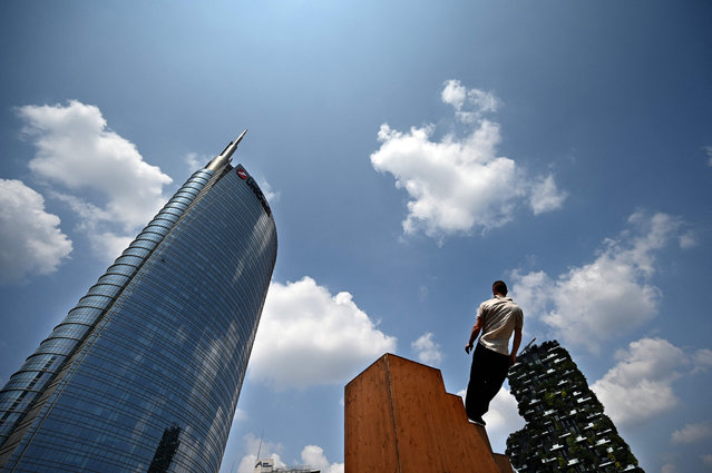 French artist Olivier Mathieu, member of the Yoann Bourgeois Art Company, performs up and down a staircase during the “Approach 18. stairs / Touch” below the Vertical forest building and the UniCredit Tower (L), as part of the second BAM Circus festival in Milan on May 28, 2023. (Photo by Gabriel Bouys/AFP Photo)