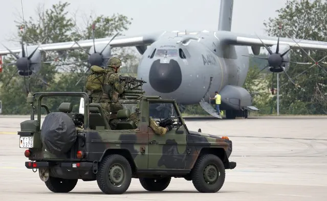 German armed forces Bundeswehr soldiers on their vehicle perform a rescue and evacuation operation as they pass a Airbus A400M military aircraft at the ILA Berlin Air Show in Schoenefeld, south of Berlin, Germany, May 31, 2016. (Photo by Fabrizio Bensch/Reuters)