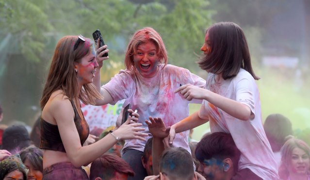 People take part in the Festival of Colors at Asanbai Park in Bishkek, Kyrgyzstan, 27 May 2023. The festival brings together young people sprinkling each other with colored powder to pay homage to India's traditional Holi festival. (Photo by Igor Kovalenko/EPA/EFE)