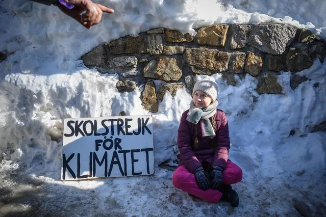 Swedish youth climate activist Greta Thunberg sits next to a placard reading “school strike for climate” on the sidelines of the World Economic Forum (WEF) annual meeting, on January 25, 2019 in Davos, eastern Switzerland. Swedish 16-year-old Greta Thunberg has inspired a wave of climate protests by schoolchildren around the world after delivering a fiery speech at the UN climate summit in Katowice, Poland last month. (Photo by Fabrice Coffrini/AFP Photo)