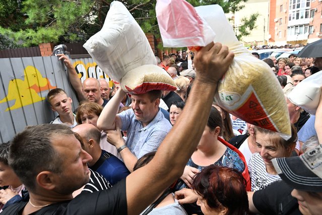 Local residents receive humanitarian aid outside the town of Sudzha on August 8, 2024. Ukraine's incursion into Russia, which entered a third day on August 8, 2024, appears to be an unprecedented assault which experts say could aim to draw Russian resources away from other areas or to undermine morale. Russia has given only scarce updates as it seeks to strike a balance between denouncing the escalation and avoiding panic. (Photo by Anatoliy Zhdanov/Kommersant Photo via AFP Photo)