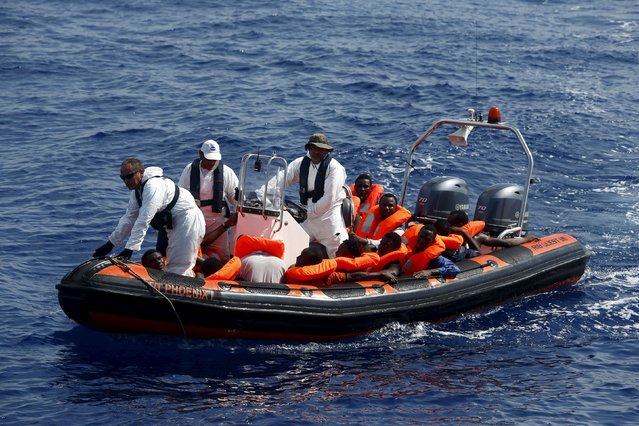 Migrants are brought to the Migrant Offshore Aid Station (MOAS) ship MV Phoenix on a MOAS RHIB (Rigid-hulled inflatable boat) after being rescued, some 20 miles (32 kilometres) off the coast of Libya, August 3, 2015. (Photo by Darrin Zammit Lupi/Reuters)