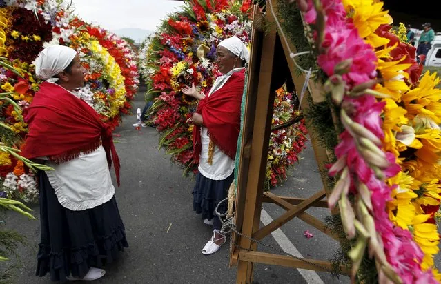 Flower growers, known as silleteros, look at flower arrangements during the annual flower parade in Medellin, Colombia, August 9, 2015. (Photo by Fredy Builes/Reuters)