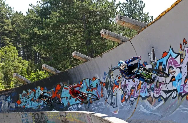 Downhill bikers Kemal Mulic (C), Tarik Hadzic (L) and Kamer Kolar train on the disused bobsled track from the 1984 Sarajevo Winter Olympics on Trebevic mountain near Sarajevo, Bosnia and Herzegovina, August 8, 2015. (Photo by Dado Ruvic/Reuters)