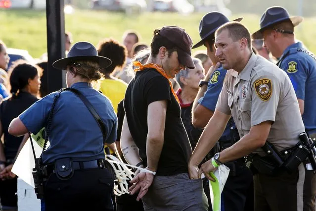 Officers from the St Louis County Police Department and the Missouri Highway Patrol process demonstrators from the “Black Lives Matter” movement who had been arrested for protesting on Interstate 70 in Earth City, Missouri, August 10, 2015. (Photo by Lucas Jackson/Reuters)