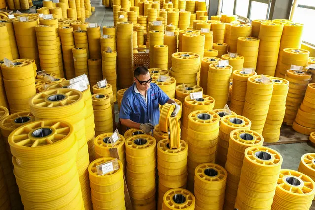 This photo taken on June 9, 2022 shows a worker producing lift rollers at a factory in Huaian, in China's eastern Jiangsu province. (Photo by AFP Photo/China Stringer Network)