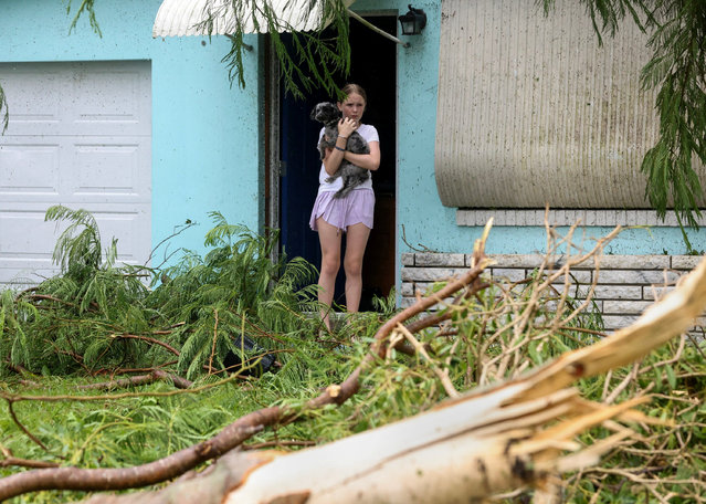 Mallory Tollett, 12, comforts her dog Maggie after a suspected tornado went through her family's property along Southeast Azimuth Way as Hurricane Milton bands move through Port Salerno, Florida, U.S., October 9, 2024. (Photo by Crystal Vander Weit/USA TODAY Network via Reuters)