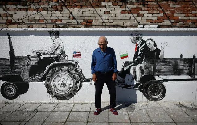 Local villager Ivan, poses next to murals on the wall of his house, depicting himself, his great grandson and U.S. President Donald Trump, in the village of Staro Zhelezare, Bulgaria, July 28, 2017. (Photo by Stoyan Nenov/Reuters)