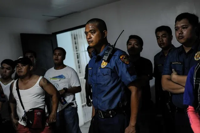 A group of policemen listen to a briefing prior to a raid on a drug den, June 16, 2016, in Manila, Philippines. (Photo by Dondi Tawatao/Getty Images)