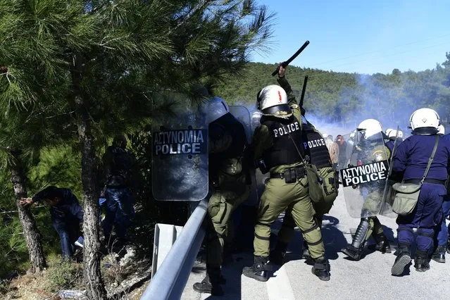 Riot police clash with protesters during a rally in Diavolorema near the area where the government plans to build a new migrant detention center, on the northeastern Aegean island of Lesbos, Greece, Tuesday, February 25, 2020. Clashes broke out overnight on the Greek islands of Lesbos and Chios, where residents tried to prevent the arrival of riot police and excavating machines to be used to build new migrant detention camps. (Photo by Michael Varaklas/AP Photo)