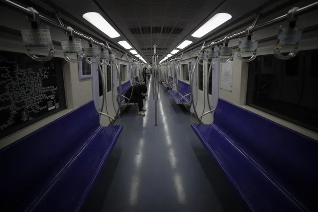 Few commuters ride in an almost empty subway train in Beijing, Monday, February 24, 2020. (Photo by Andy Wong/AP Photo)