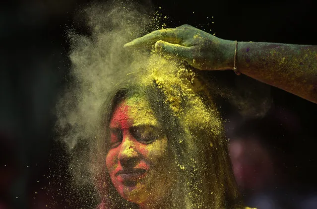 A man smears the face of a woman with colored powder during celebrations marking the Holi festival in Mumbai, India, Tuesday, March 10, 2020 (Photo by Rajanish Kakade/AP Photo)